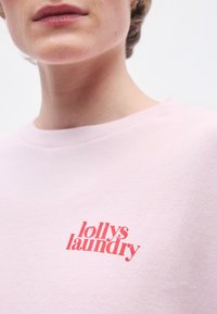 Svetloružová mikina z bavlny s červeným logom "lollys laundry" na prednej strane, okrúhlym výstrihom a rebrovanými manžetami.
