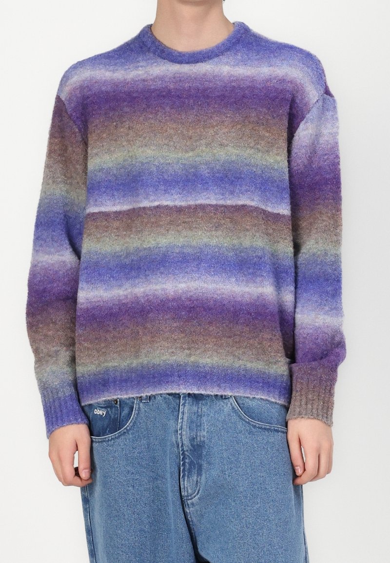 Pull en maille avec des rayures horizontales dans des tons violet, bleu et marron. Confectionné dans un matériau doux avec un col rond et des poignets côtelés.