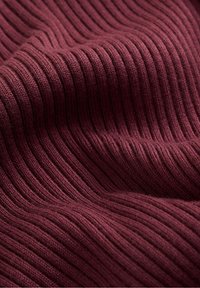 Burgundy ribbed knit fabric with a textured surface, featuring vertical stripes and a soft, stretchable quality.