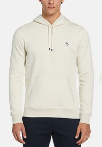 Crème-kleurige hoodie van zacht materiaal, met een voorzak, trekkoordkap en een klein pinguïnlogo op de linkerkant van de borst.