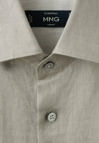 Beige slim fit MNG Essentials herreskjorte med klassisk krave og to synlige knapper lukket.