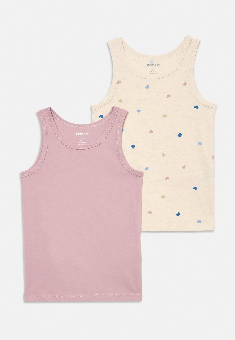 Dos camisetas sin mangas para niños, una de color lavanda sólido y otra de color crema con patrones de corazones multicolores, dispuestas sobre un fondo blanco.
