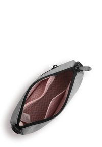 Šedá kosmetická taška se zipem; uvnitř se nacházejí tři přihrádky vyložené růžovým zigzag vzorem. Lehký materiál, elegantní design.