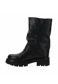 Bota negra de cuero hasta el tobillo con un diseño arrugado y cremallera lateral. Suela de goma gruesa con un dibujo profundo para mayor tracción. Textura suave con acabado pulido.