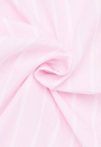 Tessuto rosa chiaro con sottili strisce verticali. Texture liscia con una leggera lucentezza, disposto in posizione piegata e drappeggiata.