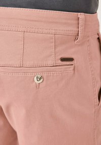 Rosa Baumwollhosen mit einer Gesäßtasche mit Knopfverschluss und einem gewebten Etikett als Akzent. Glatte Textur mit passgenauer Passform.