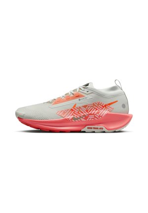 Zapatilla deportiva gris y rosa con parte superior de malla, superposiciones texturizadas, suela acolchada y un patrón gráfico distintivo.