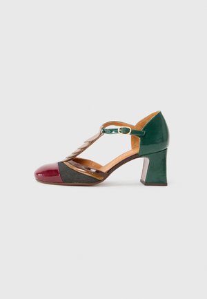 Heeled shoe with a T-strap design, featuring burgundy patent toe cap, green patent heel, brown leather accents, and black fabric side panel.