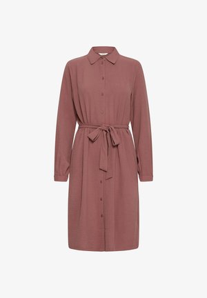 Robe chemise rose à manches longues avec un col, fermeture à boutons, et taille ceinturée. Tissu doux et texturé avec une coupe ample.