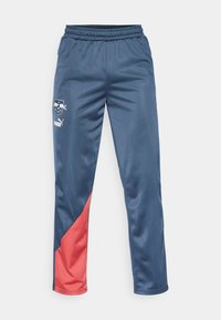 Blauwe satijnen joggers met een rode baan, elastische tailleband en PUMA-logo op het linkerpoot. Kenmerkt zich door een gladde textuur en een taps toelopend ontwerp.