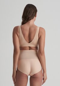 Nude saumattoman alusvaatesetin, jossa on V-mallinen selkäbralette ja korkeavyötäröiset alushousut. Sujuva, joustava kangas, vähäiset ompeluyksityiskohdat.