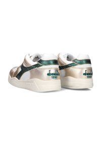 Metalen gouden en witte sneakers met groene accenten, voorzien van een mesh stof, een gevoerde kraag en geborduurd logo-detail.