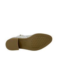 Zapato blanco perforado con una suela de goma marrón clara. Presenta un diseño sutil y un cierre de cremallera en el lateral. Suela texturizada para mayor tracción.