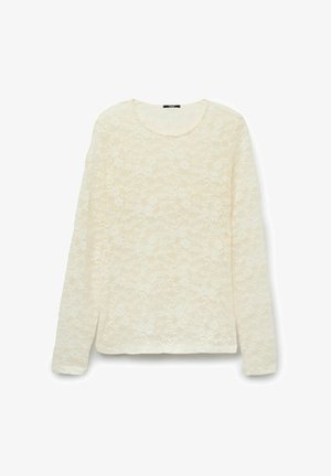 Bluzka z długim rękawem z kremowej koronki z kwiatowym wzorem i okrągłym dekoltem, prezentowana na białym tle.