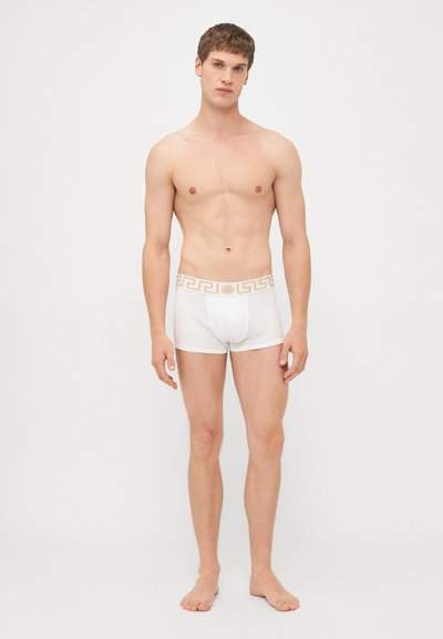 Hvide boxer shorts med et gyldent græsk nøglemønster på taljen. Blødt materiale, tætsiddende design og en enkel, klassisk pasform.