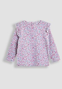 Bluse mit langen Ärmeln in Weiß mit kleinen rosa und blauen Mustern. Sie hat Rüschendetails an den Schultern und einen Schlüssellochverschluss auf der Rückseite.