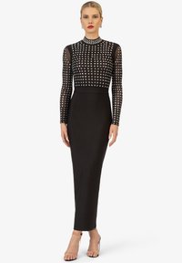 Zwarte jurk met lange, doorzichtige mouwen en een steentjes-bustes. Aansluitend ontwerp, slanke silhouet en een gladde textuur, complementair met heldere hakken.