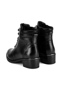 Czarne skórzane botki za kostkę z teksturowanym kołnierzem, sznurowanym z przodu i na słupku. Posiadają gładkie wykończenie i subtelne detale szycia.