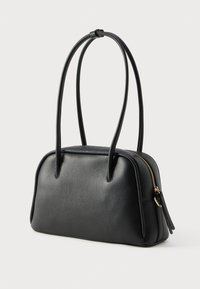 Bolso de cuero negro con un diseño estructurado, que cuenta con un cierre de cremallera, dos asas alargadas y una superficie ligeramente texturizada.