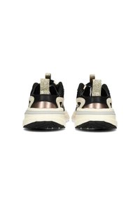 Sneaker nera con tessuto testurizzato, dettagli metallici e suola bianca spessa. Presenta un tab di tallone sollevato e un pannello posteriore con motivo.