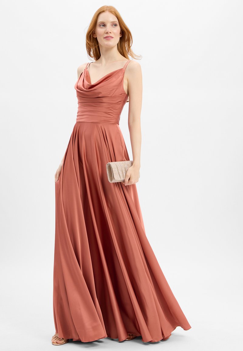 Lange, vloeiende jurk in een stofroze kleur met een boothals en een aansluitende lijf. Glad, satijnachtig materiaal; gecombineerd met een gestructureerde clutch.