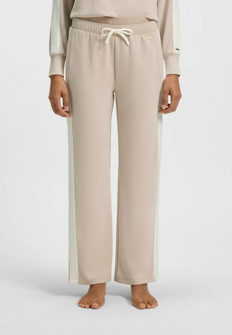 Beige sweatpants met crèmekleurige zijstrepen, voorzien van een elastische tailleband en een trekkoord. Gemaakt van zachte stof, met een ontspannen pasvorm.