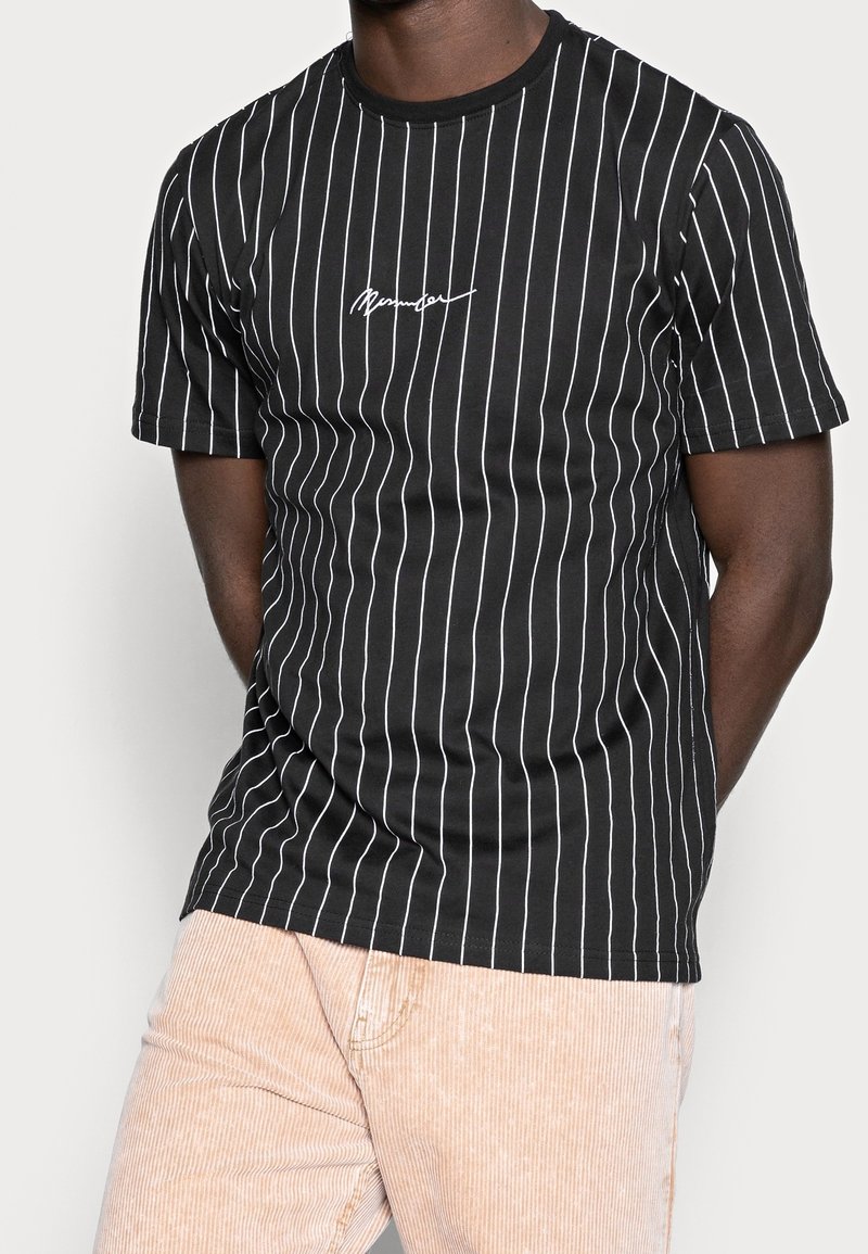Černé tričko s krátkým rukávem s vertikálními bílými pruhy a malým bílým logem na hrudi. Klasický kulatý výstřih, vyrobeno z džersejového materiálu.