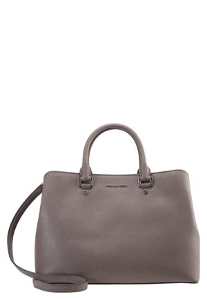 Sac à main Michael Kors en cuir taupe avec deux poignées, une bandoulière amovible et un logo argenté à l'avant, présenté sur fond blanc.