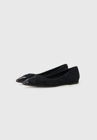 Ballerines en suede noir avec un bout pointu ; embout en cuir noir contrastant ; petit talon ; texture lisse ; design minimaliste.