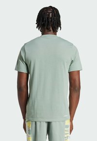 Mintgrön t-shirt med kort ärm, tillverkad av mjukt material, med rund halsringning och en enkel design utan synliga logotyper eller mönster.