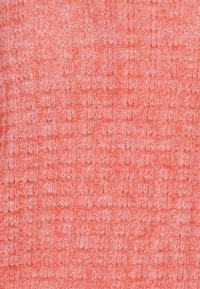 Gestrickter Stoff in einem sanften Korallenton, der ein strukturiertes Muster mit subtilen Farbvariationen und einer leicht flauschigen Oberfläche aufweist.