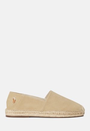 Beige ruskinds-espadille med lukket tå og ryg, ydersål af jute reb og et lille broderet logo på den ydre side.
