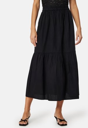 Zwarte, enkellange, gelaagde rok met een elastische tailleband. Gemaakt van lichte stof, met een eenvoudige, vlakke textuur en zonder zichtbare patronen.