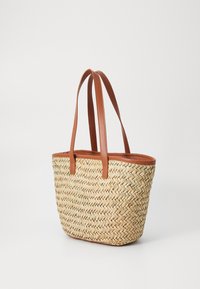 Geflochtene Strohtasche mit braunen Ledergriffen, rechteckiger Form, heller Farbe, strukturierten Oberfläche und einem soliden Lederbesatz an der Oberseite.
