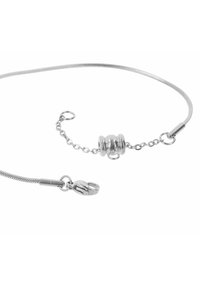 Bracciale in argento con un design texturizzato, caratterizzato da una perla centrale e una chiusura a gancio. La catena è fine e flessibile, accentuando il suo aspetto delicato.