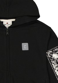 Czarna bluza z kapturem na zamek błyskawiczny z szarym haftowanym logo na piersi, białym kwiatowym nadrukiem na rękawie oraz miękką teksturą materiału.