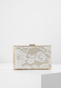 Gouden rechthoekige clutch met witte kant en bloemenpatroon. Voorzien van een stijlvolle sluiting en glad materiaal, liggend op een witte ondergrond.