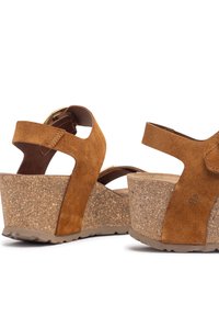 Sandales compensées en suede marron avec plateforme en liège, dotées de deux brides à la cheville et d'une semelle texturée pour une meilleure adhérence.