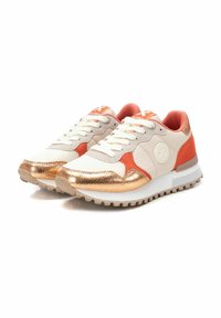 Zapatillas con un upper de malla y cuero beige, acentos en naranja, detalles metálicos dorados y una suela de goma texturizada.