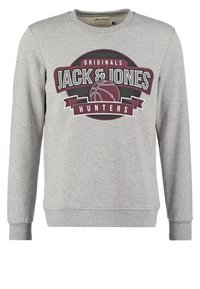 Sudadera gris con cuello redondo, mangas largas y un gran estampado gráfico que dice "JACK & JONES HUNTERS" con un diseño de baloncesto.