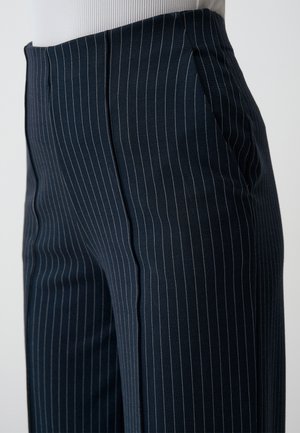 Marineblaue, gestreifte Hosen aus dehnbarem Stoff mit glatter Textur. Sie verfügen über schräge Seitentaschen und eine taillierte Passform.