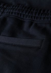 I joggers blu navy presentano una vita elastica texturizzata e una tasca piatta sul retro, realizzati in un morbido tessuto elasticizzato.