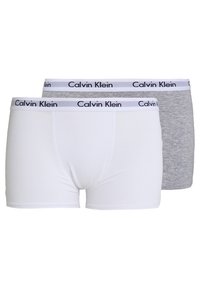 Dvaja muži majú boxerky; jedny biele, druhé šedé. Každé má čierny pás s logom Calvin Klein a sú vyrobené z mäkkej, pružnej látky.