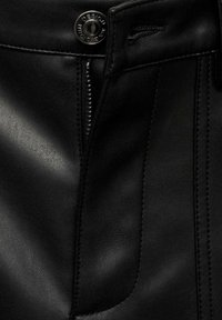 Černé kožené kalhoty s zipem, knoflíkovým zapínáním a viditelnými švy na přední straně. Hladká textura s přiléhavým střihem.