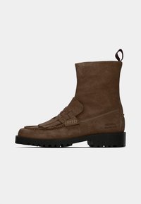 Bottines en suède marron avec une semelle en caoutchouc noir plat, ornées d'un accent à franges et d'une languette à l'arrière pour un enfilage facile.