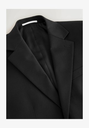 Black tailored suit jacket with notch lapels, visible stitching on buttonhole, and smooth fabric texture on a light background.