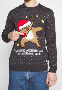 Maglione grigio scuro in maglia con design di una renna che indossa un cappello di Babbo Natale rosso, che fa un dab, e la scritta "DABBING AROUND THE CHRISTMAS TREE."
