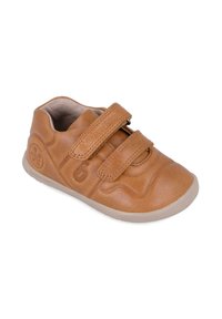 Zapato infantil de cuero marrón claro con dos correas de Velcro, punta redondeada, parte superior texturizada y suela de goma. Presenta un logotipo embosado en el lateral.