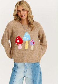 Brązowy sweter dziany z trzema kolorowymi aplikacjami grzybów: czerwonym, niebieskim i fioletowym w białe kropki z przodu. Teksturowany materiał.