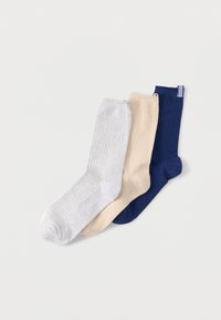 Três pares de meias caneladas em cinza claro, creme e azul-marinho. Cada meia apresenta uma textura suave e um design de comprimento até ao meio da perna.
